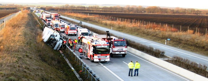 Foto: Verkehrsunfall auf der BAB 71 © Stadtverwaltung Erfurt Feuerwehr und Rettungsdienstfahrzeuge neben einem umgekippten LKW auf der Autobahn